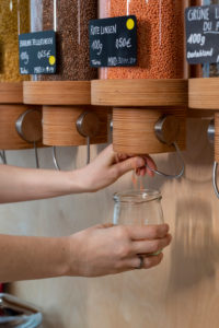 Woman fills lentils into a glass, detail from an unwrapped shop. Woman fills lentils into a glass, detail from an unwrapped shop.